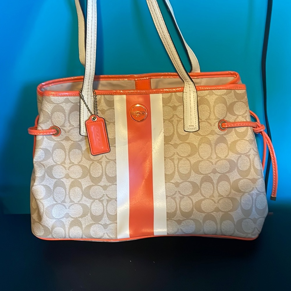 Orange, white, and brown Coach purse with a wallet